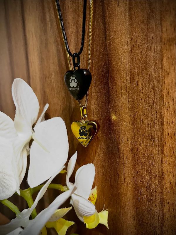 Dije de corazón con huella colgado junto a orquídeas blancas
