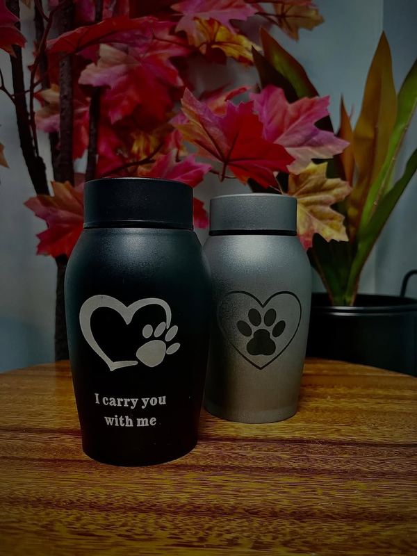 Dos tibores, negro y gris, con corazón y huella grabados