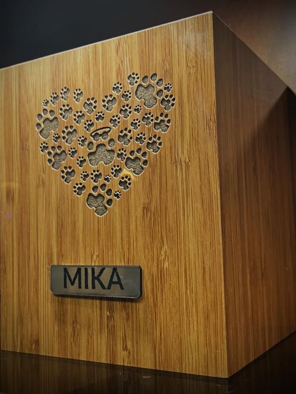 Urna de bambú con corazón de huellas y placa con el nombre Mika